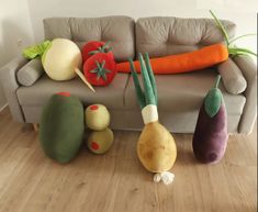 an assortment of vegetables sitting on the floor in front of a couch