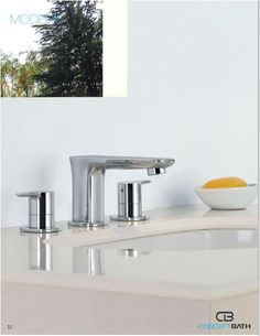 two faucets sitting on top of a white counter next to a bowl of fruit