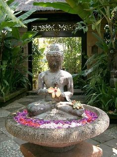 a buddha statue sitting in the middle of a garden