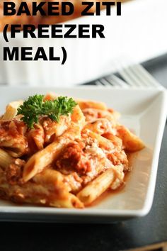 a white plate topped with pasta and meat covered in sauce on top of a table