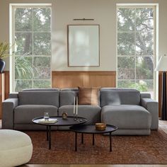 a living room with two couches and a coffee table in front of large windows