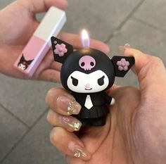 a person holding a small black and white cat candle