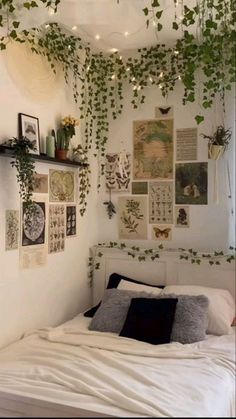 an unmade bed with lots of plants growing on the wall and hanging above it