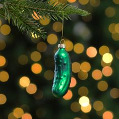 a green ornament hanging from a christmas tree