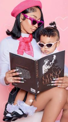 a woman is reading a book to a little boy wearing sunglasses and a pink hat