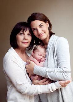 two women holding a baby in their arms