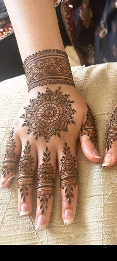 two hands with henna tattoos on them