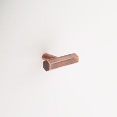 a small wooden object on a white surface