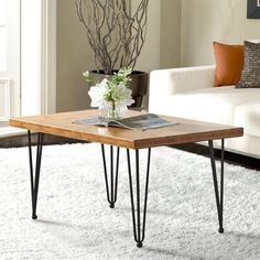 a living room with a white couch and wooden coffee table in it's center