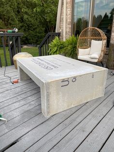 a concrete bench sitting on top of a wooden deck