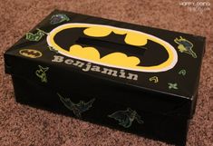 a batman themed box is sitting on the floor in front of a carpeted area