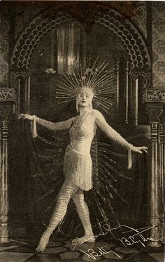 an old fashion photo of a woman standing in front of a doorway with her arms outstretched