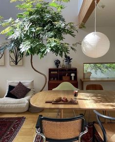 a living room filled with furniture and a tree in the middle of it's center