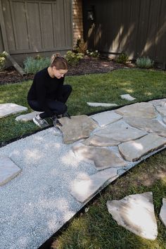 a woman kneeling down on top of a stone walkway