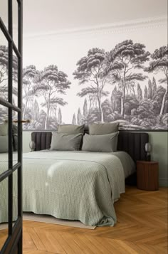 a bedroom with a large wall mural behind the bed and pillows on the headboard