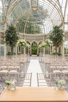 the inside of a building with rows of chairs and tables set up for a wedding ceremony