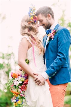 a man and woman standing next to each other with flowers in their hair on their foreheads