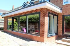 a brick house with large windows and sliding glass doors