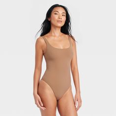 This 4-Way Stretch Tank Bodysuit from Auden™ in a solid color features a sleeveless silhouette with a breezy scoop neckline, cotton gusset for breathability and snap buttons on the crotch. Made from lightweight four-way stretch fabric it offers a comfortable fit that moves with you, and the opaque lining offers confident wear. You can wear this pullover bodysuit with everything from wide-leg trousers to joggers to shorts, and add layering pieces for versatile styling options. Auden™: Comfort tru Solid Color Tank Bodysuit For Beach, Beach Fitted Tank Bodysuit, Fitted Tank Bodysuit For The Beach, Fitted Sleeveless Bodysuit For Daywear, Solid Color Scoop Neck Tank Top With Lined Body, Solid Scoop Neck Tank Top With Lined Body, Seamless One-piece Tank Top For Summer, Seamless One-piece Summer Tank Top, Solid Spring Scoop Neck Swimwear