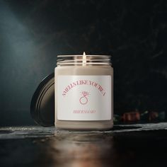 a candle that is sitting on top of a table in front of a dark background