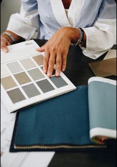 a person sitting at a table working on some color samples