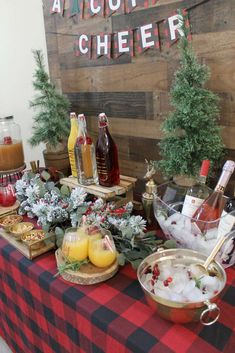 a table topped with bottles of wine and glasses filled with drinks on top of a checkered table cloth