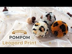 three pompom leopard print donuts on a white cloth with gold glitters