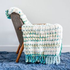 a crocheted blanket sitting on top of a chair