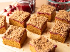 several pieces of cake on a cutting board with cranberry sauce in the background