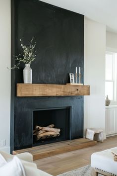 a living room with a black fireplace and white furniture