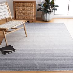 a modern rug in the corner of a room with a chair and potted plant