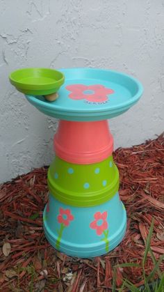 three plates stacked on top of each other in front of a white wall and grass