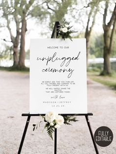 a welcome sign for an unplugged ceremony with white flowers and greenery