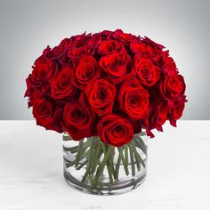 a vase filled with red roses on top of a table