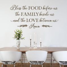 a dining room table with four chairs and a wall decal