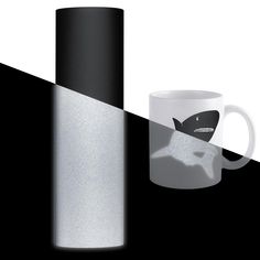 a black and white coffee mug next to a tall cylindrical cup with a shark on it