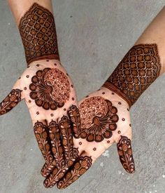 two hands with henna designs on them