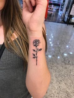 a woman with a rose tattoo on her wrist