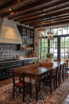 a dining room table and chairs in front of an open kitchen with lots of windows