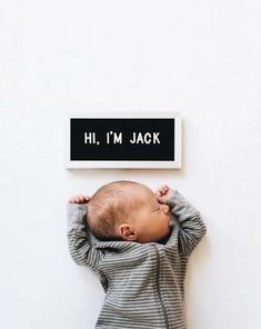 a baby is laying on his back next to a sign that says hi, i'm jack