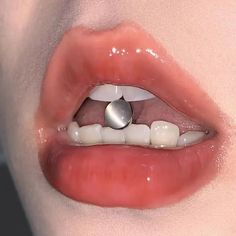 a woman's mouth with an object in the middle of her lip and tongue