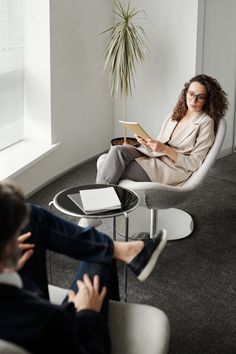 a woman sitting in a chair reading a book