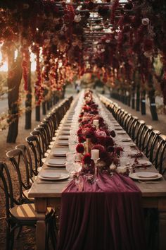 a long table is set up with place settings and flowers on it for an elegant dinner