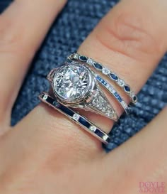 a woman's hand with three different rings on top of her finger and the other ring