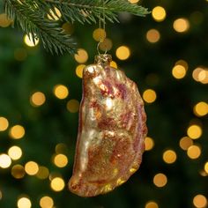 a christmas ornament hanging from a tree with lights in the backround