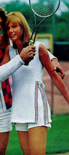 two tennis players hugging each other with rackets in their hands and one holding the racquet