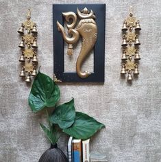 an elephant head is mounted on the wall next to some books and vases with plants