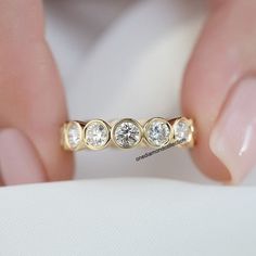 a woman's hand holding a diamond ring with three stones on the inside of it