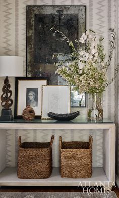 a shelf with baskets and flowers on it