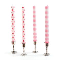 three candles with pink and white polka dots on them are lined up in a row